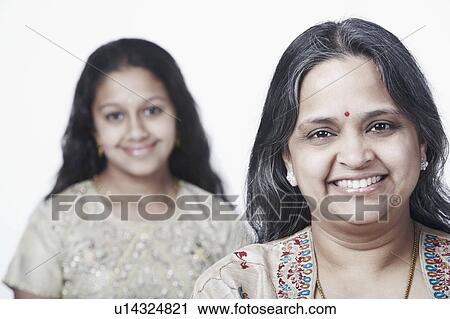 Portrait of a mature woman smiling with her daughter standing behind her View Large Photo Image Stock Image - Portrait of a mature woman smiling with her daughter standing behind her. Fotosearch