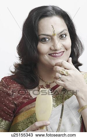 Stock Image - Portrait of a mature woman with a hairbrush in her hand. Fotosearch