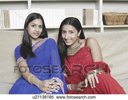 Portrait of two young women sitting on a couch View Large Photo Image Stock Photography - Portrait of two young women sitting on a couch. Fotosearch