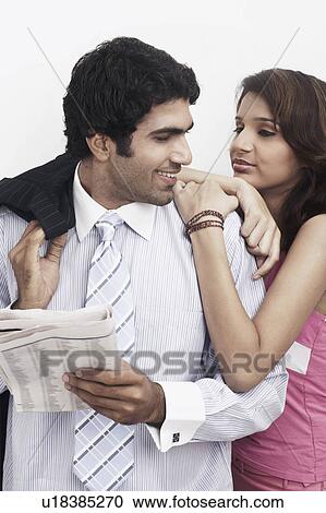 Businessman standing with a young woman leaning on him View Large Photo Image Stock Image - Businessman standing with a young woman leaning on him. Fotosearch