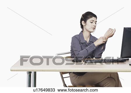 Stock Image - Businesswoman adjusting her cuff link. Fotosearch