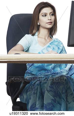 Stock Image - Businesswoman sitting in front of a computer. Fotosearch