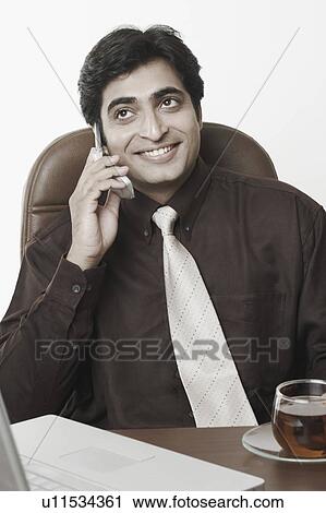 Close-up of a businessman talking on a mobile phone View Large Photo Image Stock Image - Close-up of a businessman talking on a mobile phone. Fotosearch