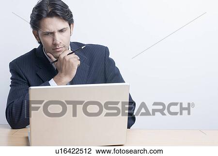 Close-up of a businessman using a laptop and thinking View Large Photo Image Stock Image - Close-up of a businessman using a laptop and thinking. Fotosearch