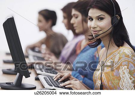 Picture - Close-up of four businesswomen sitting in front of computers. Fotosearch