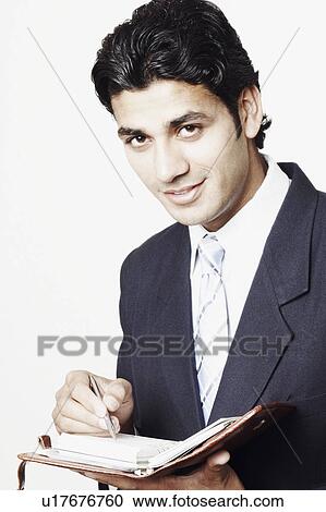 Stock Image - Portrait of a businessman holding a personal organizer. Fotosearch