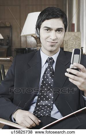 Stock Photo - Portrait of a businessman holding a mobile phone. Fotosearch