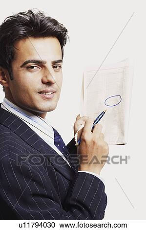 Portrait of a businessman marking on a newspaper View Large Photo Image Stock Image - Portrait of a businessman marking on a newspaper. Fotosearch