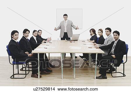 Picture - Portrait of a businessman showing thumbs up in a conference room. Fotosearch