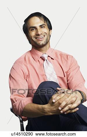 Portrait of a businessman sitting on a chair and smiling View Large Photo Image Stock Image - Portrait of a businessman sitting on a chair and smiling. Fotosearch