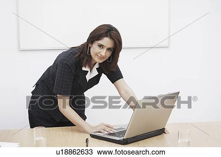 Stock Image - Portrait of a businesswoman using a laptop. Fotosearch