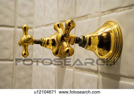 Stock Image - Tile Shower Wall and Old-Fashioned Brass Knobs. Fotosearch