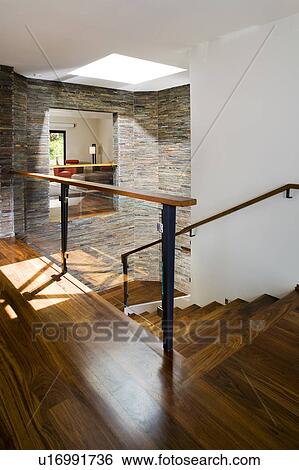 Stock Photograph - Hardwood Stairwellwith Stone Tile Walls. Fotosearch
