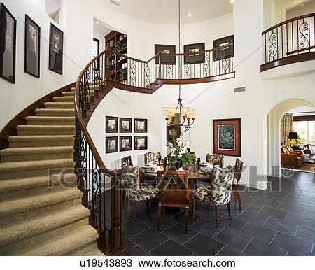 Stock Image - Interior of dining room with wrapping staircase and catwalk. Fotosearch