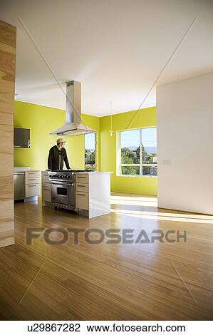 Stock Image - Man Standing in Mdern Kitchen. Fotosearch