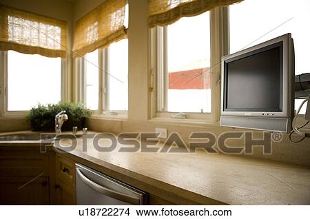 Picture - Vignette of kitchen counter and flatscreen tv. Fotosearch