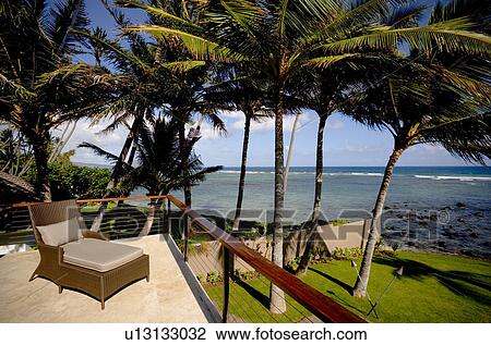 Stock Image - Deck Chair on Balcony Patio by Ocean. Fotosearch