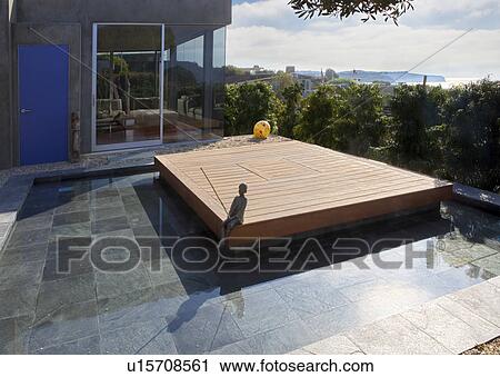 Stock Image - Deck Surrounded by Small Pond. Fotosearch