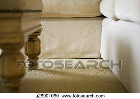 Stock Image - Low perspective detail of couch and table legs. Fotosearch