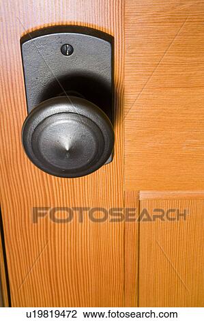 Stock Image - Wood Door with Wrought Iron Doorknob. Fotosearch