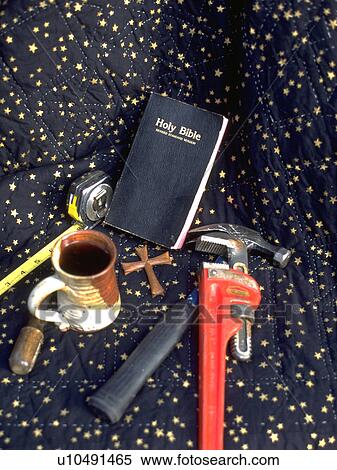 Stock Photography - Repairman's tools, Bible, cross, mug, wrench, tape measure, screwdriver, and hammer. Fotosearch