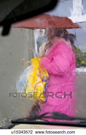 Shopper leaving grocery store with umbrella in the rain View Large Photo Image Stock Image - Shopper leaving grocery store with umbrella in the rain. Fotosearch