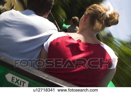 Stock Image - Black Hair, Blurred, Blond Hair, Amusement Park. Fotosearch