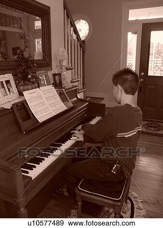 A young boy with diabetics enjoys playing the piano. View Large Photo Image Stock Photo - A young boy with diabetics enjoys playing the piano.. Fotosearch
