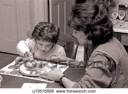 Little girl with autism and other disabilities in the process of learning to eat independently with some assistance from her mother. View Large Photo Image Stock Photo - Little girl with autism and other disabilities in the process of learning to eat independently with some assistance from her mother.. Fotosearch