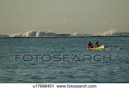 Stock Image - A couple in a boat in the sea, Moorea, Tahiti, French Polynesia, South Pacific. Fotosearch