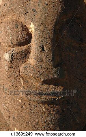Stock Photo - Close-up of a face carved in stone, Moorea, Tahiti, French Polynesia, South Pacific. Fotosearch