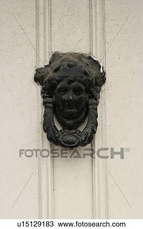 Stock Image - Door knocker on white door. Fotosearch