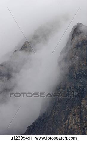 Stock Image - Fog enveloping a mountain, Rocky Mountains, Canada. Fotosearch