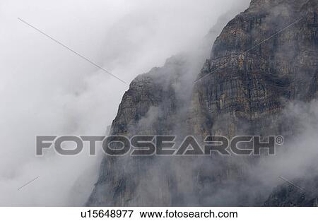 Fog enveloping a mountain, Rocky Mountains, Canada View Large Photo Image Stock Photo - Fog enveloping a mountain, Rocky Mountains, Canada. Fotosearch