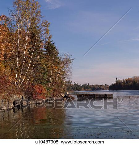 Stock Photography - Lake shoreline in autumn colours. Fotosearch