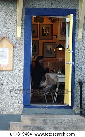 Picture - Person sitting in an establishment in a town, Rocky Mountains, Canada. Fotosearch
