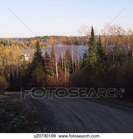 Stock Photo - Scenic autumn view of lake and forest from road. Fotosearch