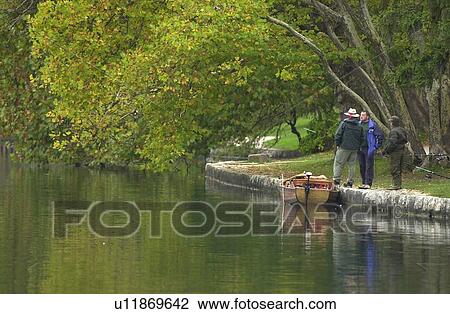Three people standing on the banks of a river in Slovenia View Large Photo Image Stock Image - Three people standing on the banks of a river in Slovenia. Fotosearch