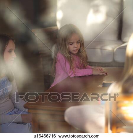 Two girls sitting at a table View Large Photo Image Stock Photograph - Two girls sitting at a table. Fotosearch