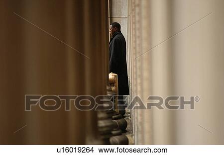 Young man standing in a building View Large Photo Image Picture - Young man standing in a building. Fotosearch