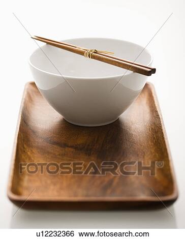 Stock Photograph - Asian bowl with chopsticks on wooden tray. Fotosearch