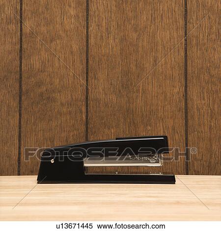 Black stapler on desk with wooden paneling. View Large Photo Image Stock Photography - Black stapler on desk with wooden paneling.. Fotosearch
