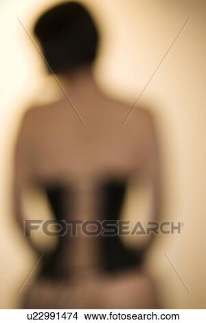Picture - Blurred rear view shot of young woman wearing corset. Fotosearch