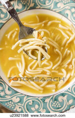 Bowl of chicken noodle soup with spoon View Large Photo Image Stock Photo - Bowl of chicken noodle soup with spoon. Fotosearch