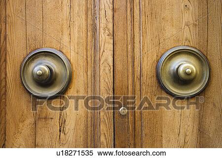 Stock Photography - Brass doorknobs on wooden door with lock.. Fotosearch