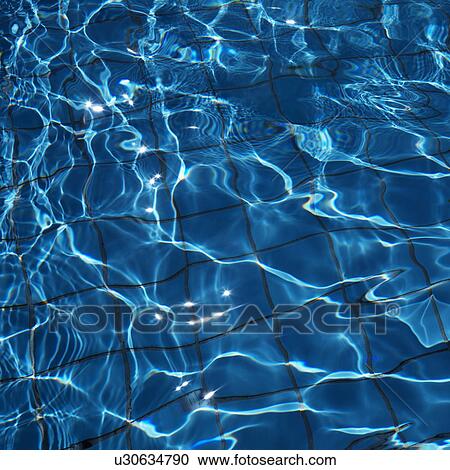 Stock Image - Close-up of blue reflective rippling water with grid pattern in bottom of pool. Fotosearch
