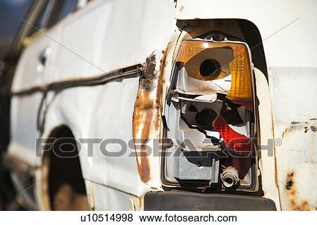Stock Photo - Close-up of busted taillight on rear end of old abandoned and rusted car.. Fotosearch
