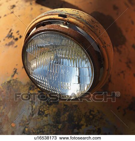 Stock Image - Close-up of headlight on scratched up rusty old pick-up truck. Fotosearch