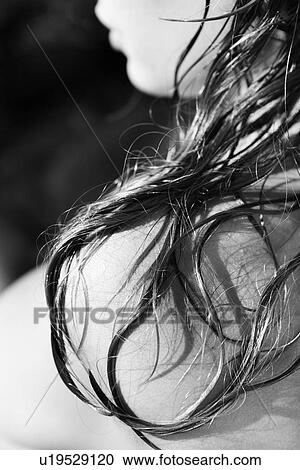 Stock Image - Close up of long hair resting on woman's shoulder. Fotosearch
