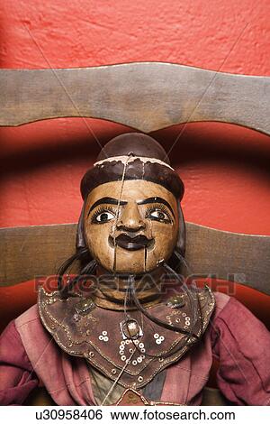 Close up of wooden puppet sitting on chair View Large Photo Image Stock Photograph - Close up of wooden puppet sitting on chair. Fotosearch